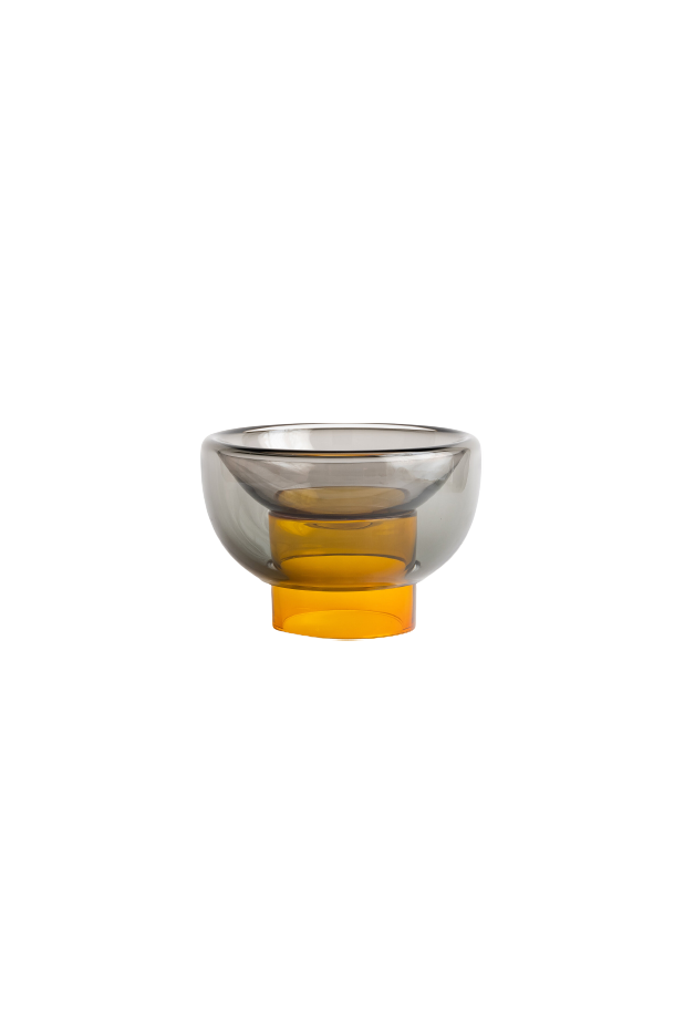 semi-transparent yellow cylinder glass base holding a semi-transparent grey moon shape glass forming a bowl on a white background